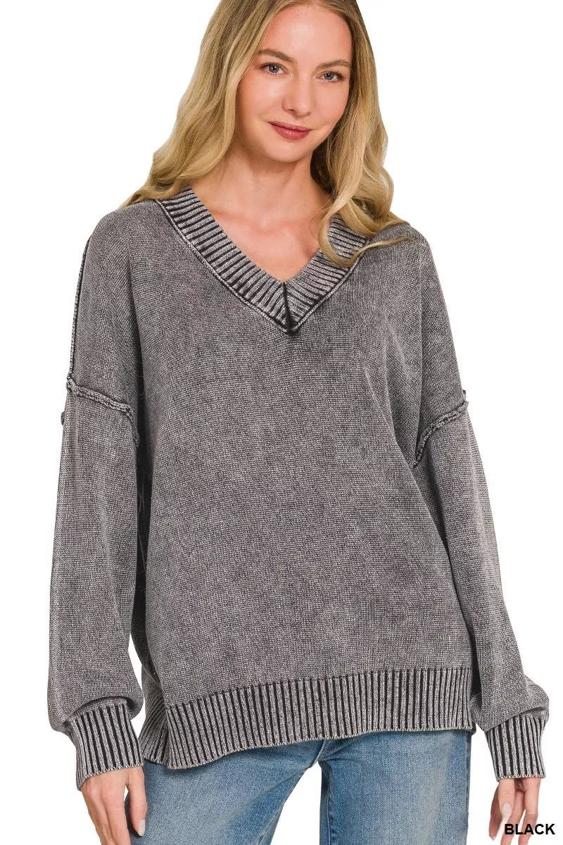 Woman wearing a gray sweater with a V-neck and ribbed details on a white background