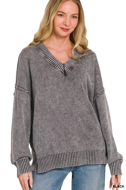 Woman wearing a gray sweater with a V-neck and ribbed details on a white background
