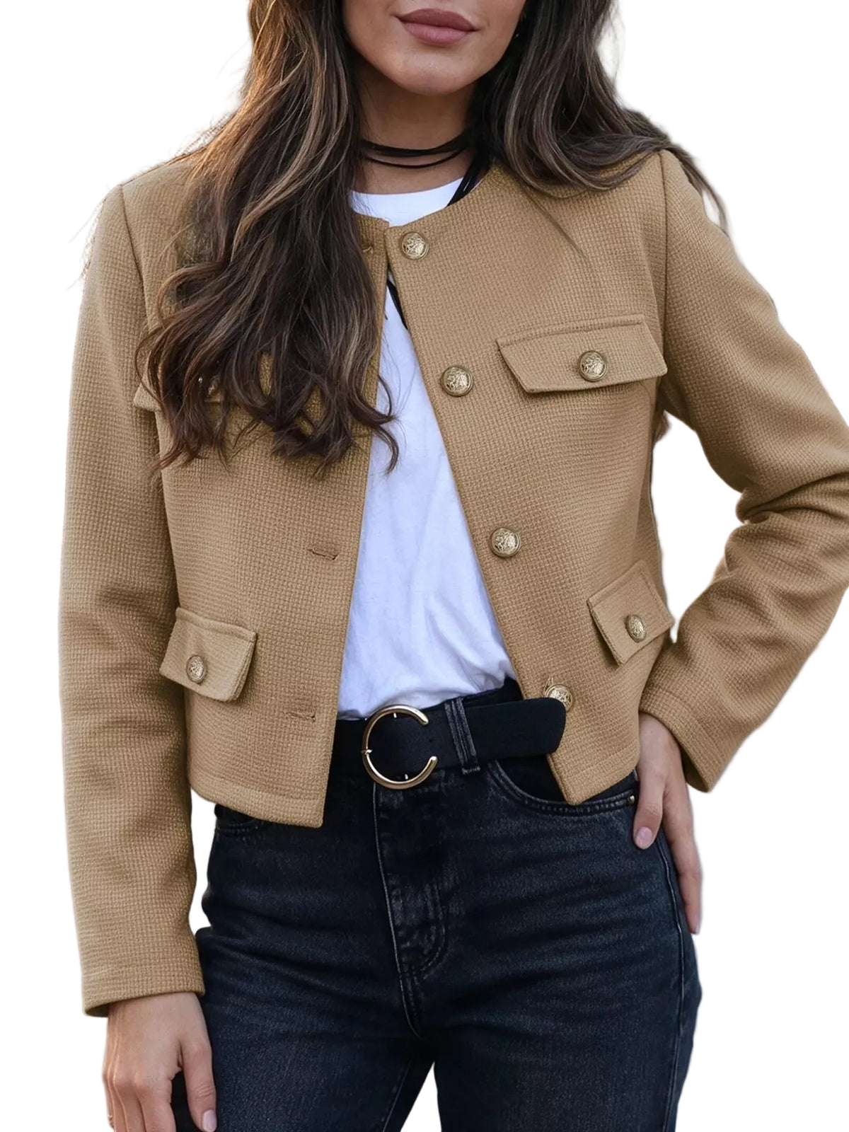 A woman wearing a cropped tan textured jacket with gold-tone buttons over a white t-shirt and dark jeans.