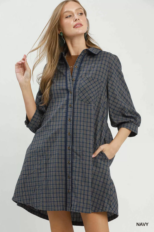 Woman wearing a navy plaid dress on a white background