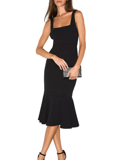 A woman modeling a sleeveless black midi dress with a square neckline, fitted silhouette, and flared ruffled hem, standing against a plain light wall.