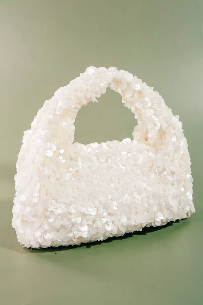 White textured handbag on a light green background