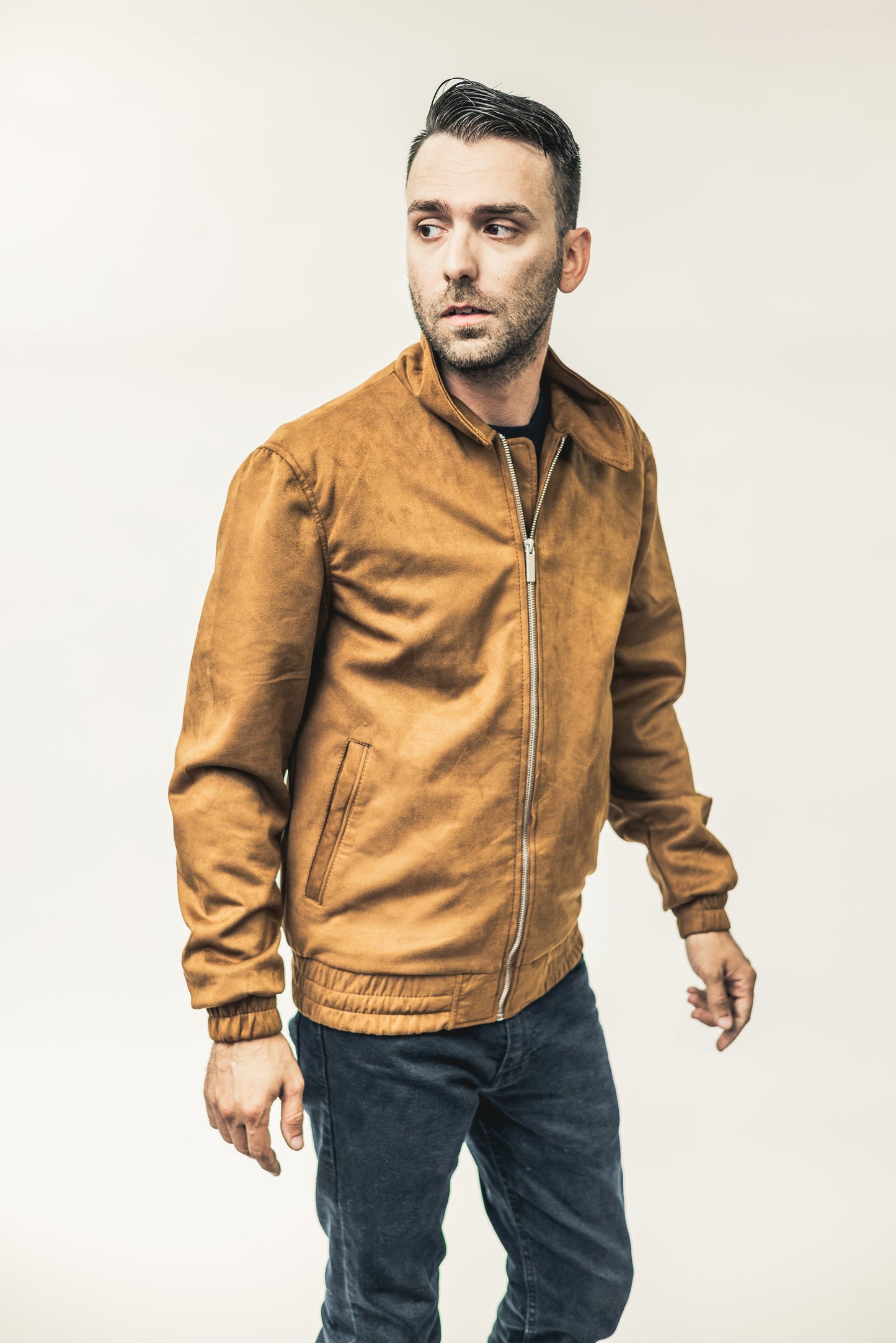 Man wearing a brown leather jacket against a plain background