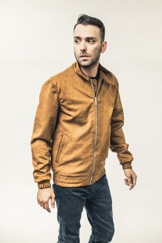 Man wearing a brown leather jacket against a plain background
