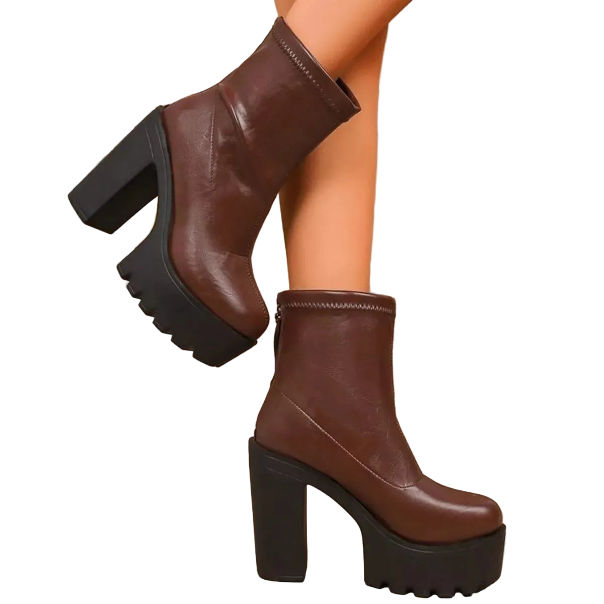 Brown platform boots with black soles worn by a person, against a wooden background.