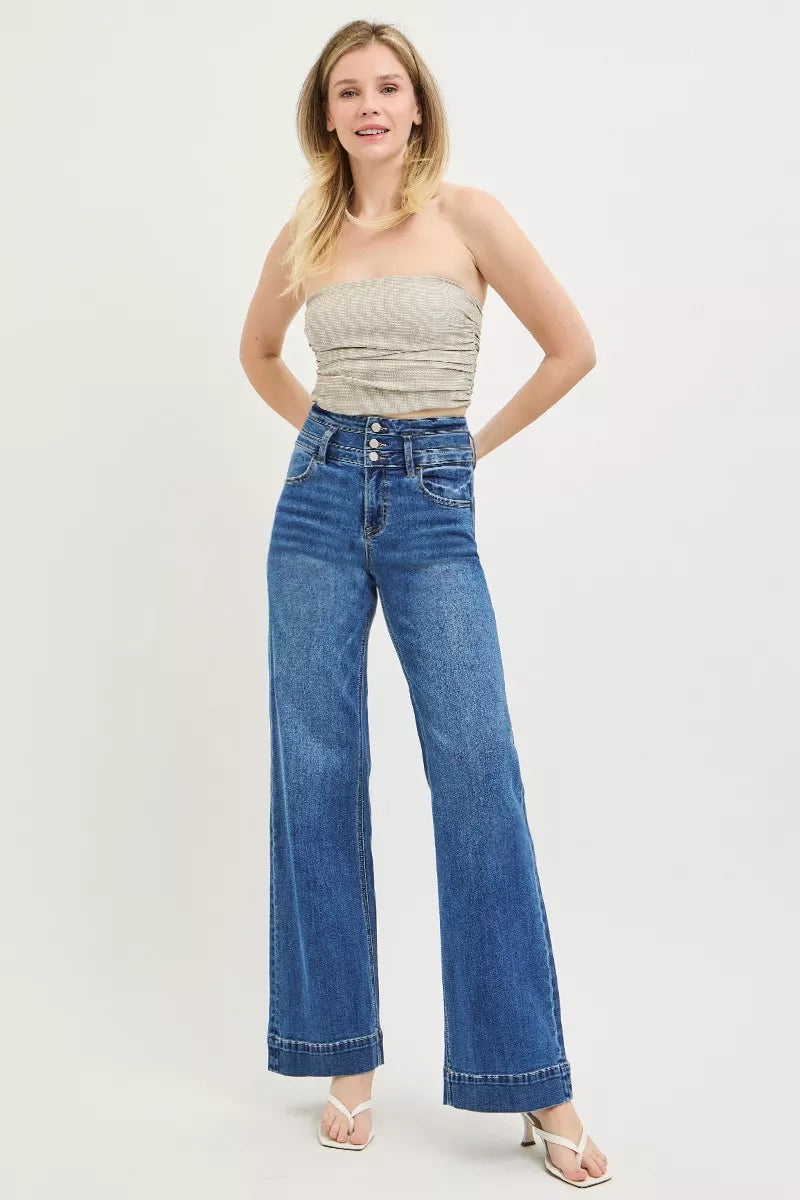 Woman wearing a strapless top and blue jeans on a white background