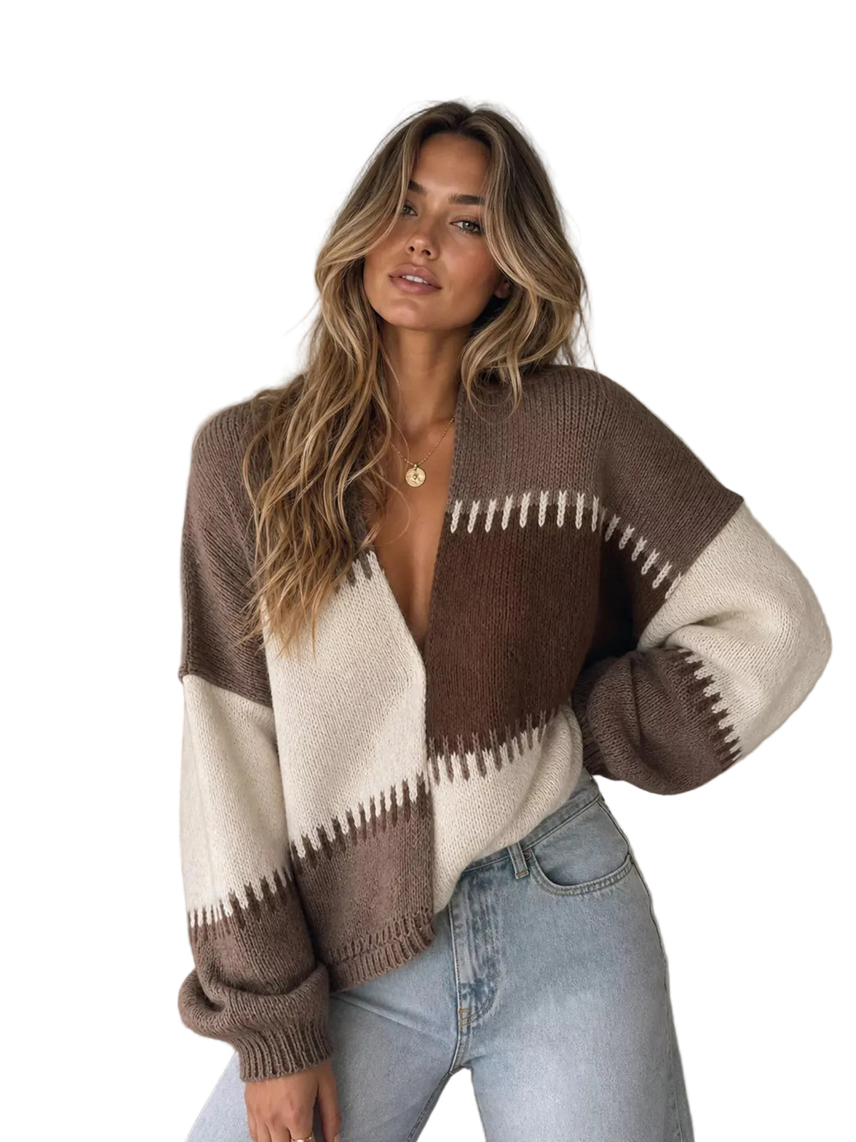 A woman wearing a brown and cream color-blocked knit cardigan sweater with zigzag stitching details, paired with light-wash blue jeans, standing in a neutral indoor setting.