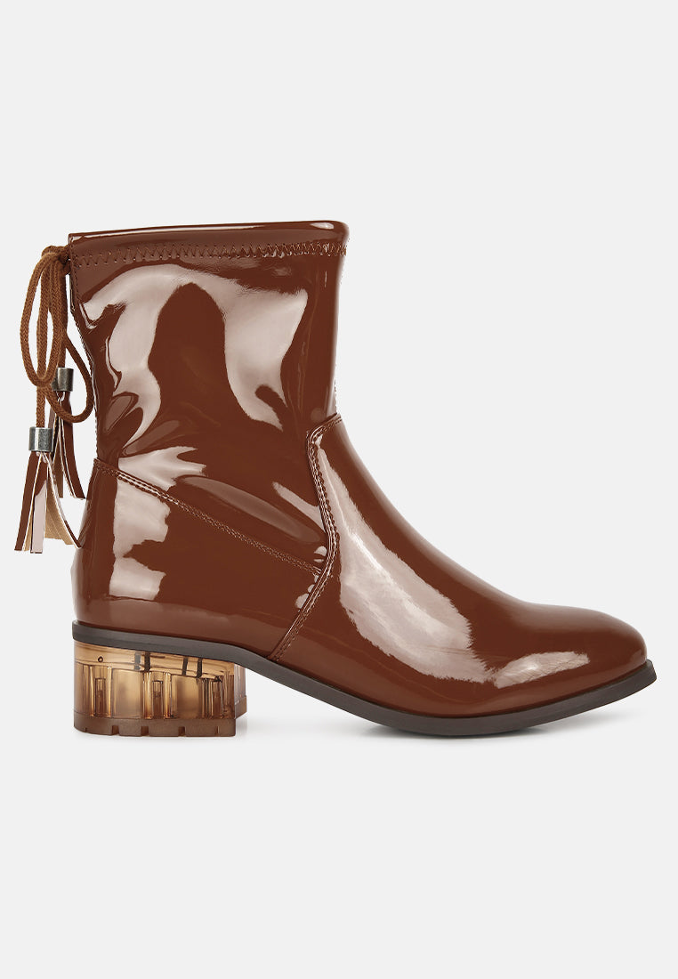Brown patent leather boot with tassels on a white background