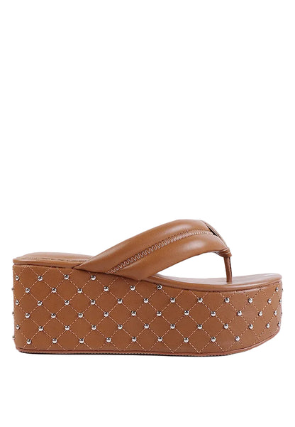 Brown platform sandal with studded details on a white background