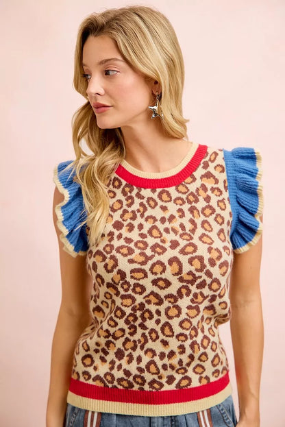Woman wearing a leopard print sweater with blue ruffled sleeves on a pink background