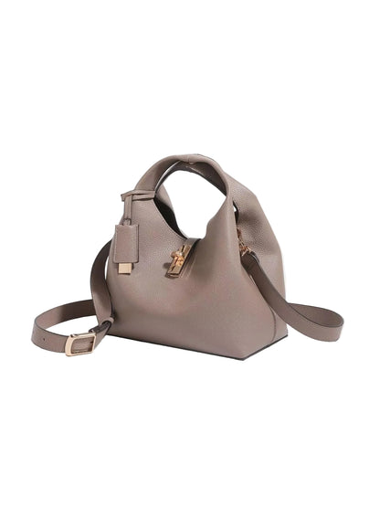 A taupe pebbled leather handbag with a top handle, detachable shoulder strap, and gold-tone hardware, shown on a light gray background.