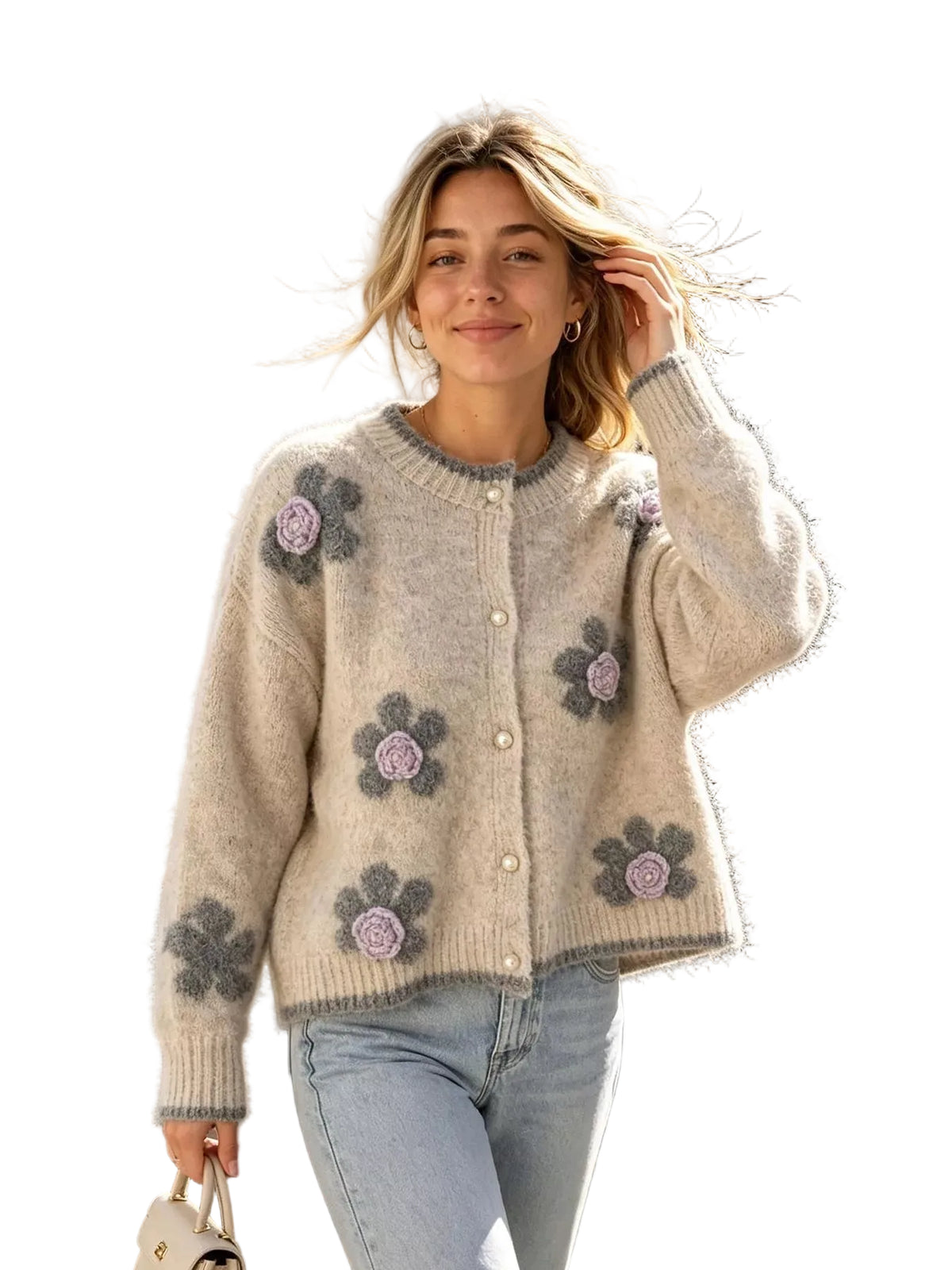 A woman wearing a fuzzy cream cardigan with gray and lavender floral patches, paired with light blue jeans, walking outdoors on a sidewalk with fallen leaves.