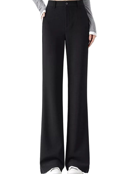 Black wide-leg trousers shown on a model from the waist down, paired with a gray long-sleeve top and white sneakers against a plain white studio background.