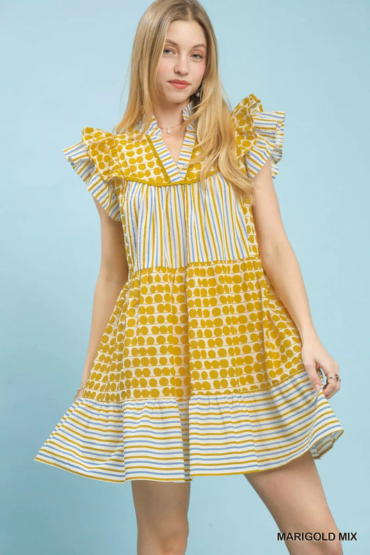 Woman wearing a yellow and white patterned dress on a light blue background