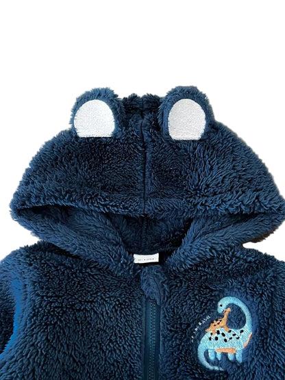 A dark blue plush hooded zip-up jacket with frog ears on the hood and a giraffe graphic on the chest, shown laid flat on a beige paper bag.