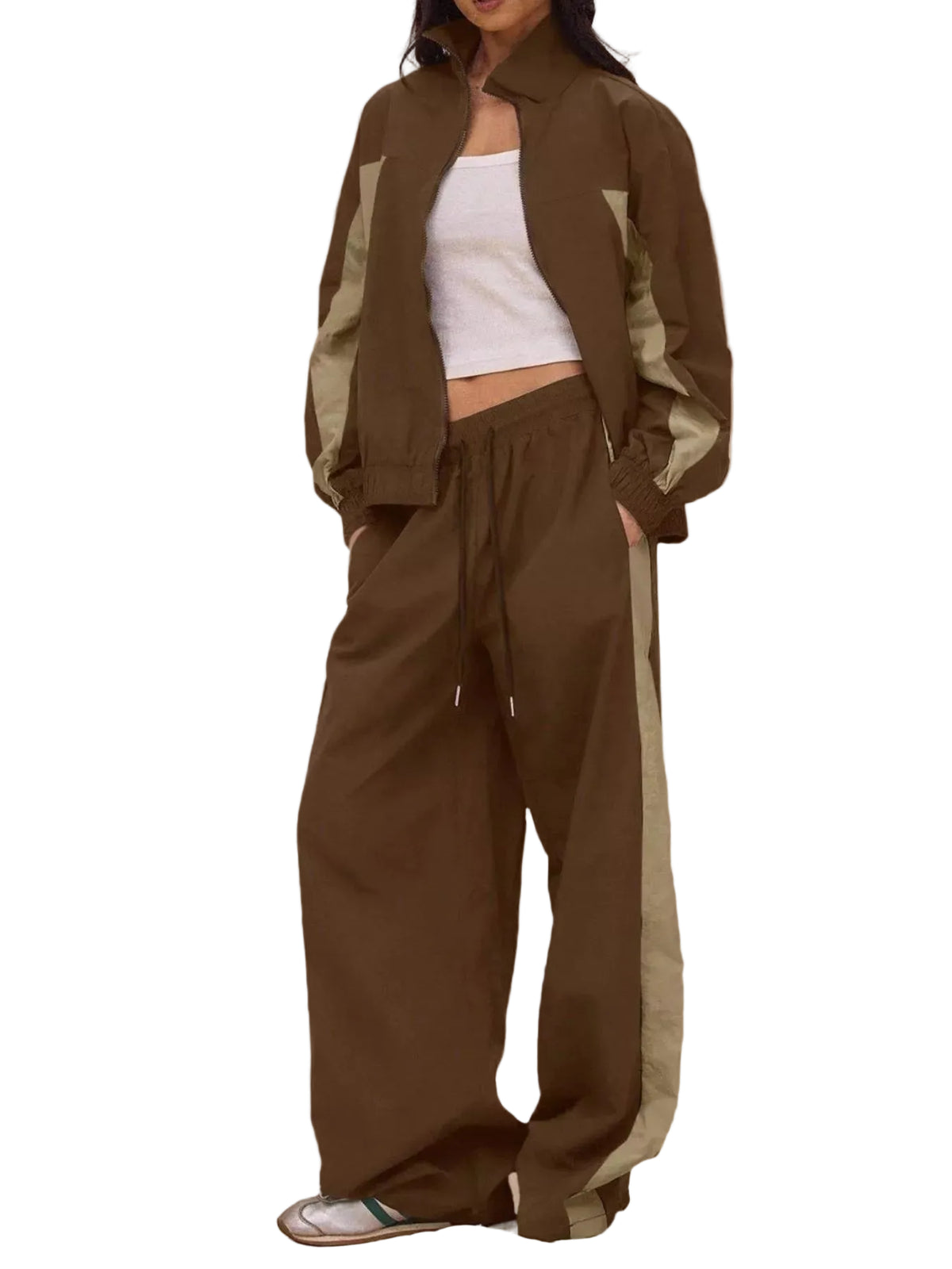 A model wearing a matching brown color-blocked track jacket and wide-leg sweatpants with olive green side panels, styled with a white crop top and silver sneakers against a solid beige backdrop.