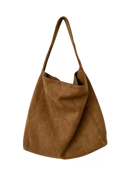Brown suede handbag on a white background