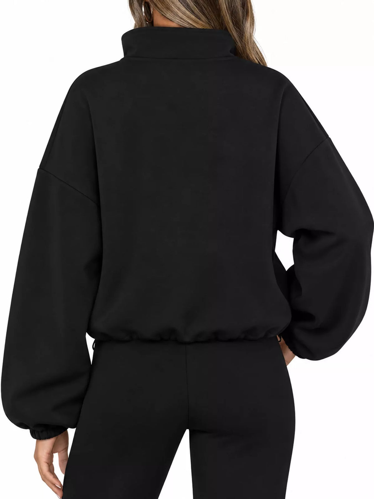 A person shown from the back wearing a black cropped sweatshirt with a mock neck and voluminous long sleeves, paired with black pants, against a plain white background.