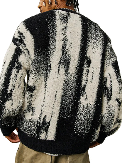 A person shown from the back wearing a fuzzy knit sweater with a black and off-white abstract vertical pattern, paired with khaki pants, against a plain gray studio background.