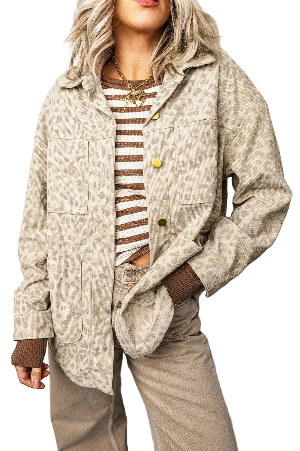 A woman wearing a beige and brown leopard-print jacket over a brown and white striped top, paired with brown pants, photographed against a light gray studio background.