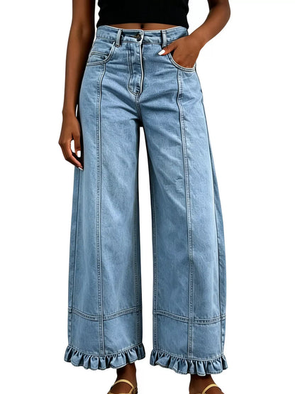 A person wearing light-wash blue wide-leg denim jeans with a ruffled hem, shown from the waist down against a plain white background.