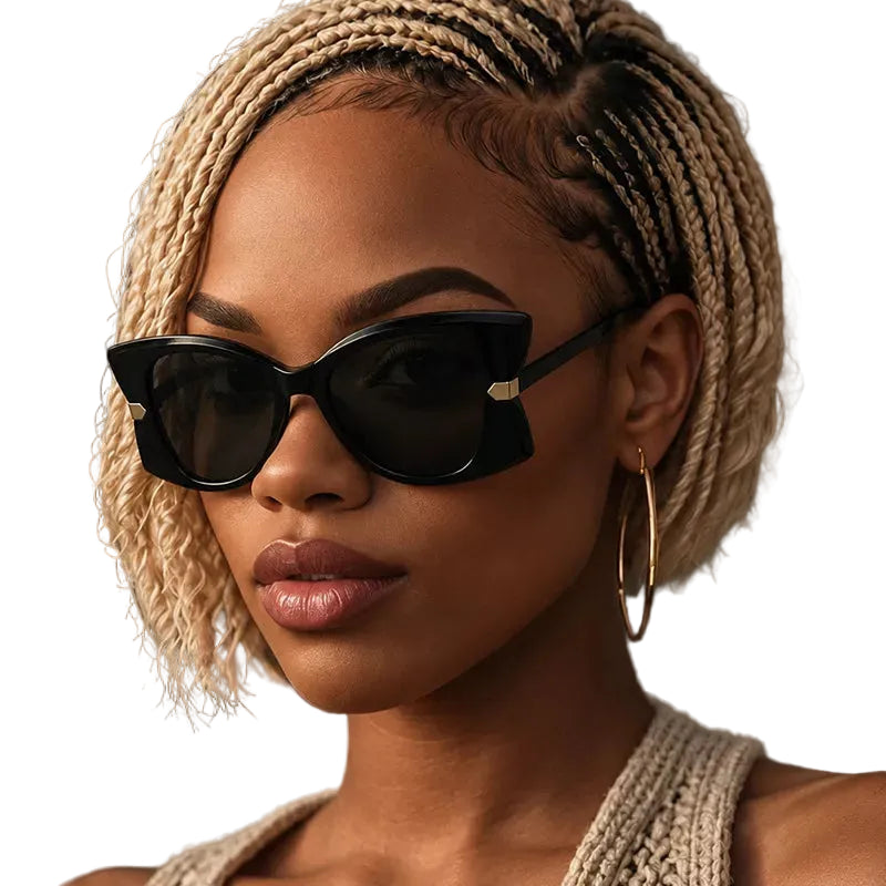 A close-up portrait of a woman with braided blonde hair wearing black cat-eye sunglasses with gold metal hinges and gold hoop earrings, set against a dark gray background.