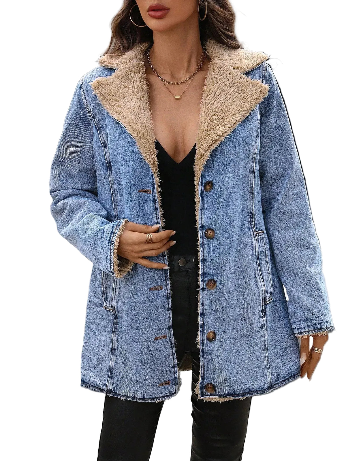 A woman wearing a light blue denim jacket with a beige sherpa lining, styled over a black top and black pants, standing on a street crosswalk.