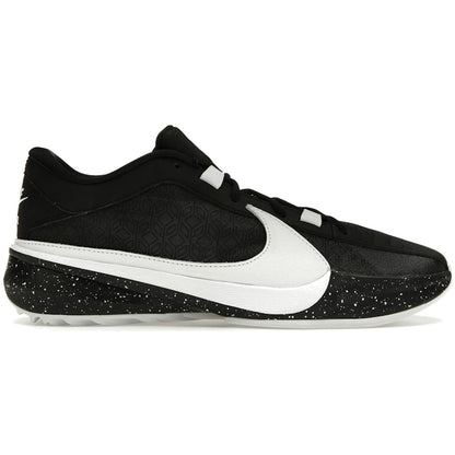 A Nike athletic shoe in black and white, featuring a black textured upper, a large white Swoosh, and a black and white speckled sole, shown from a side profile on a white background.