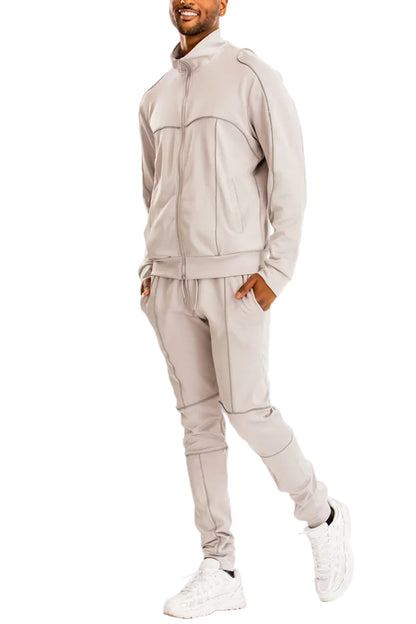 Man wearing a beige tracksuit on a white background