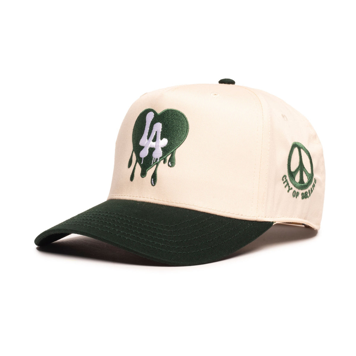 A structured baseball cap with a cream-colored crown and a dark forest green brim. The front features a green dripping heart graphic with a white '44' inside, and the side displays a green peace sign with 'CITY OF NEW YORK' text.