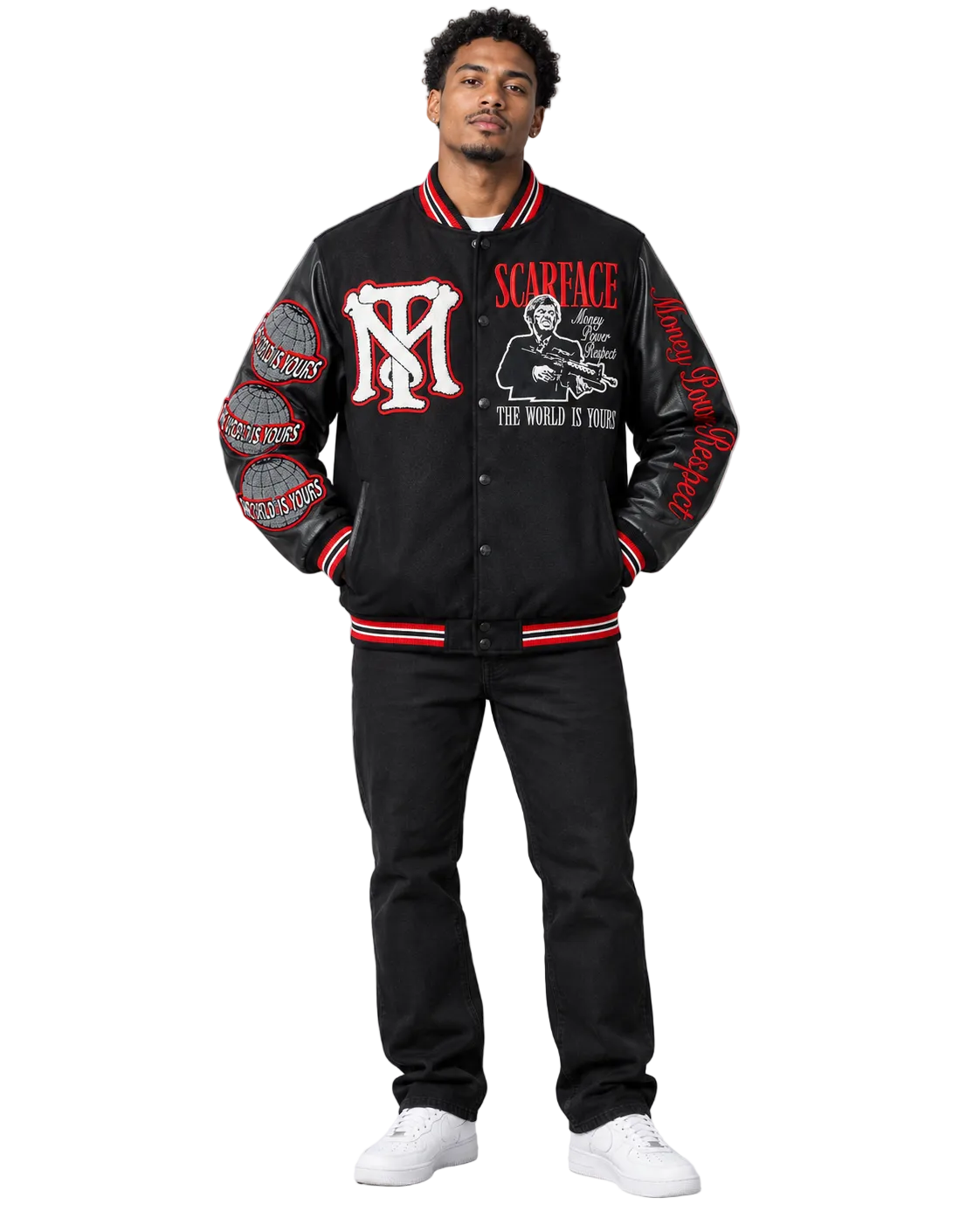A man modeling a black varsity-style jacket with red and white striped ribbed trim, featuring a large red and white 'M' logo on the chest, 'SCARFACE' text, and graphic prints on the sleeves, paired with black pants and white sneakers against a light gray studio background.
