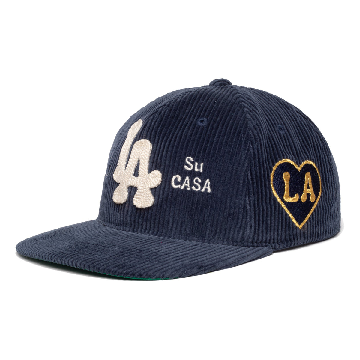 A navy blue corduroy baseball cap with embroidered details. The front features a large cream-colored 'LA' logo and the text 'Su CASA' in white, while the side displays a gold-outlined heart patch with 'LA' in black.