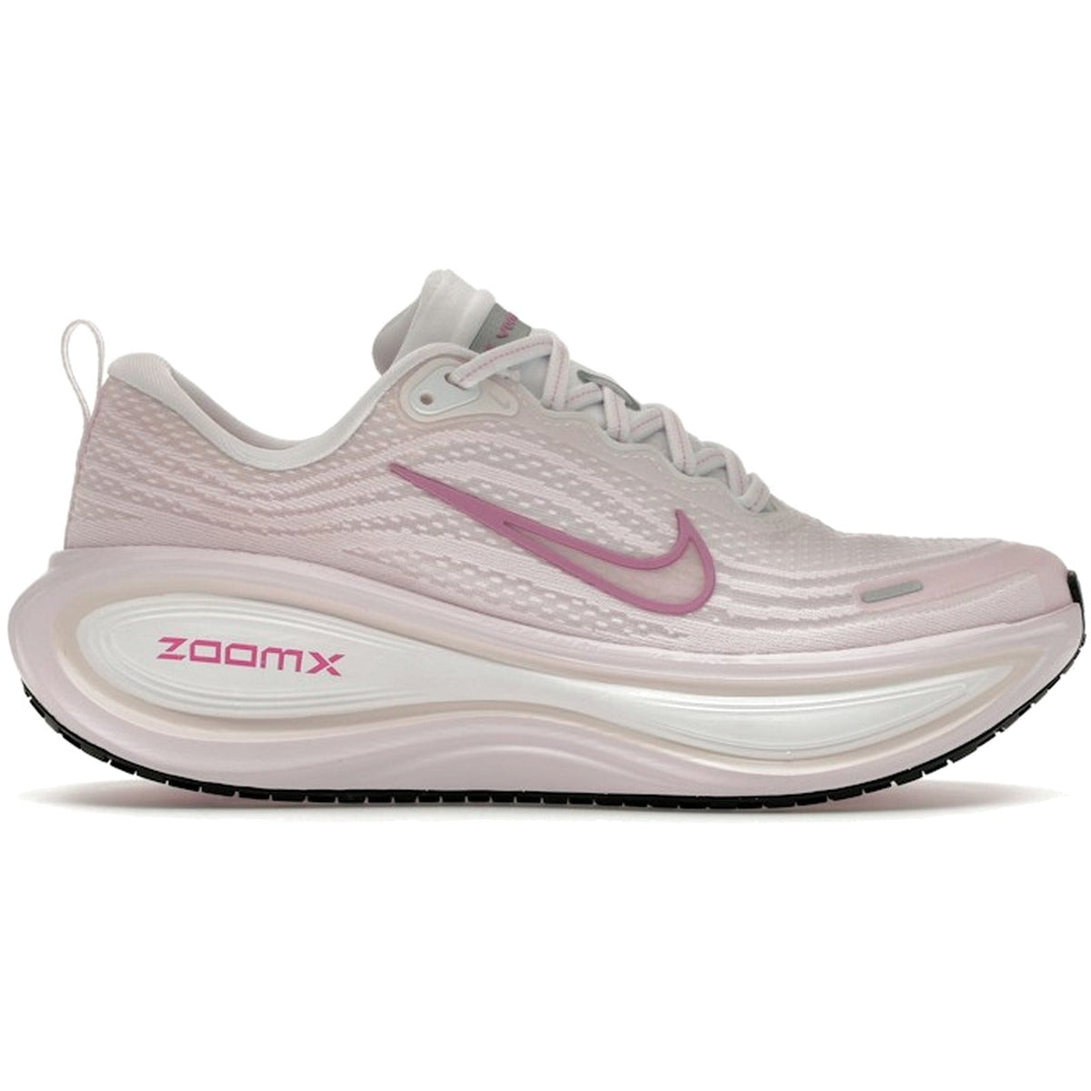 A Nike running shoe in light pink and white with a metallic pink Swoosh logo and pink 'ZOOMX' text on the midsole, shown from a side profile on a white background.