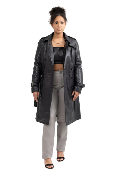 Woman wearing a long black coat over a black top and gray pants on a white background