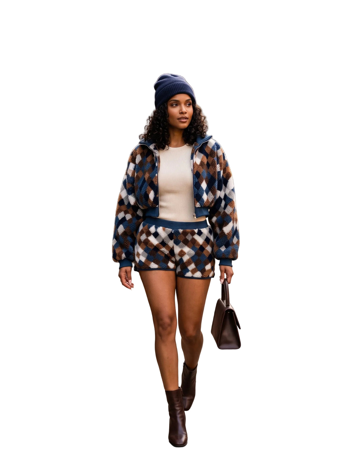 A woman walking on an autumn city sidewalk wearing a matching navy, brown, and beige argyle patterned jacket and shorts set, a cream top, a navy beanie, and brown ankle boots.