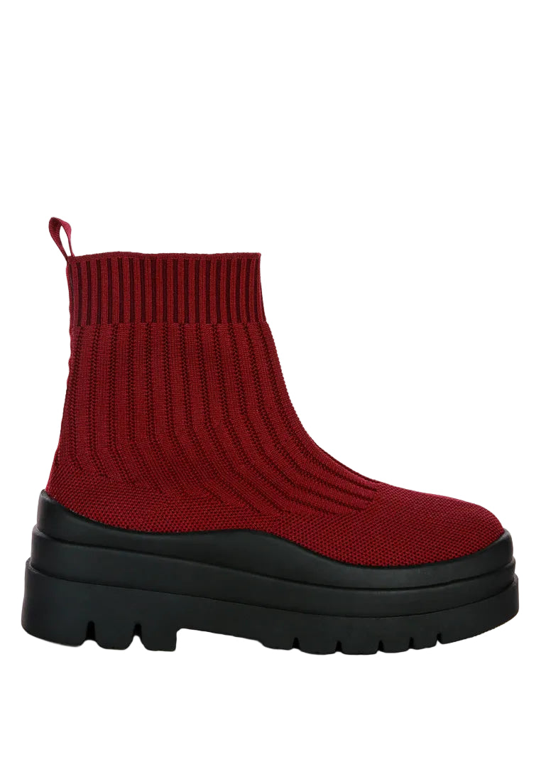 A single red knit ankle boot with a chunky black platform sole, shown from a side profile against a light gray background.