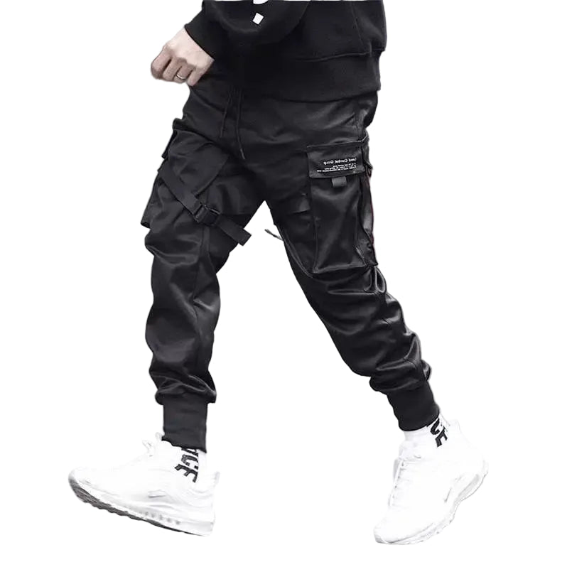 Person wearing black cargo pants and white sneakers on a blurred street background